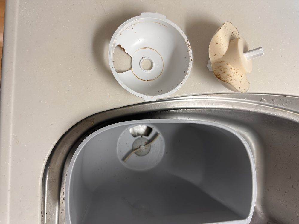 分解して取り外したカリカリマシーンのパーツ。茶色い汚れが付いている